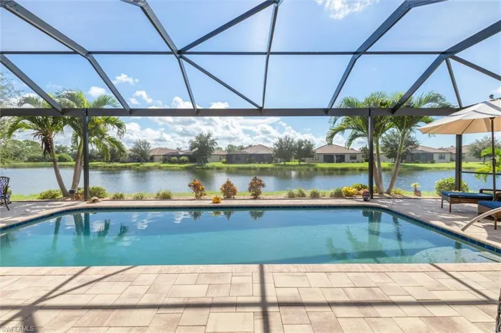 Swimming pool featuring a lanai, a water view, a sunroom, and a residential view