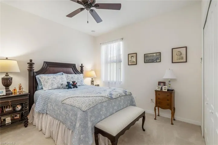 Bedroom with light colored carpet, a ceiling fan, and a closet