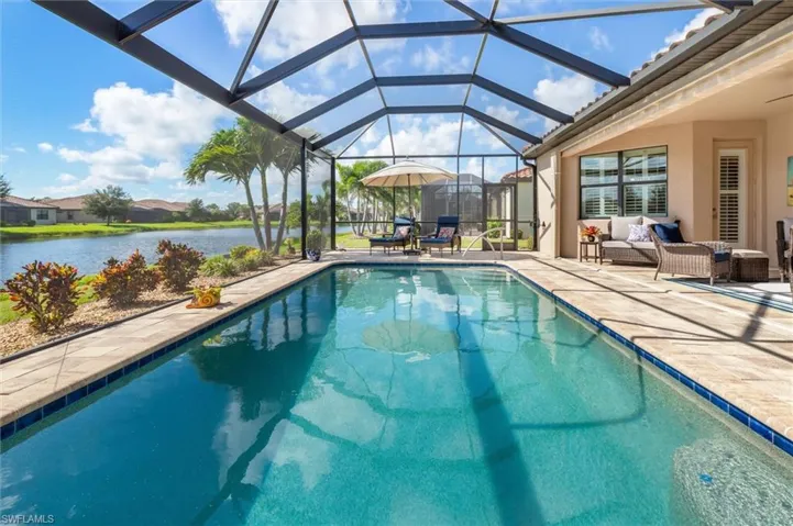 Swimming pool with a sunroom, glass enclosure, a patio area, an outdoor hangout area, and a water view