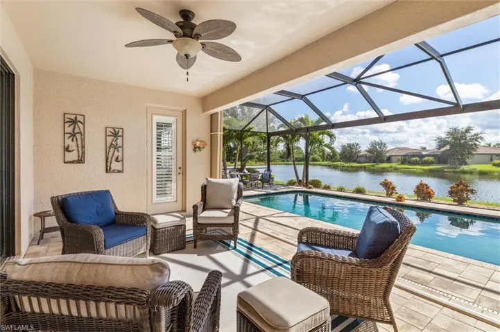 Swimming pool with a patio area, a sunroom, a lanai, a water view, and ceiling fan