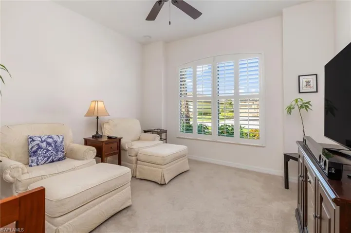 Sitting room with light colored carpet and a ceiling fan