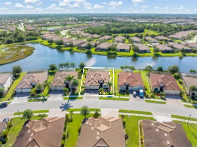 Aerial perspective of suburban area with property boundaries highlighted and a large body of water