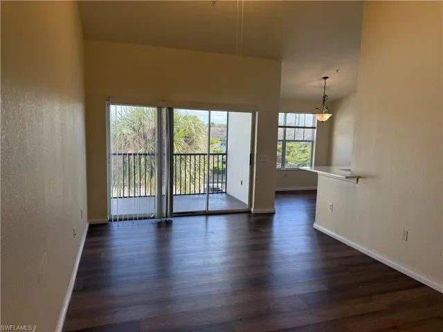 Spare room with a textured wall and dark wood finished floors
