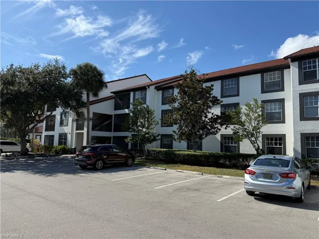 View of apartment building / complex with uncovered parking