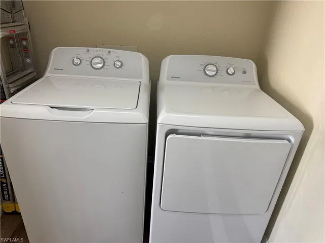 Laundry area featuring separate washer and dryer and a textured wall