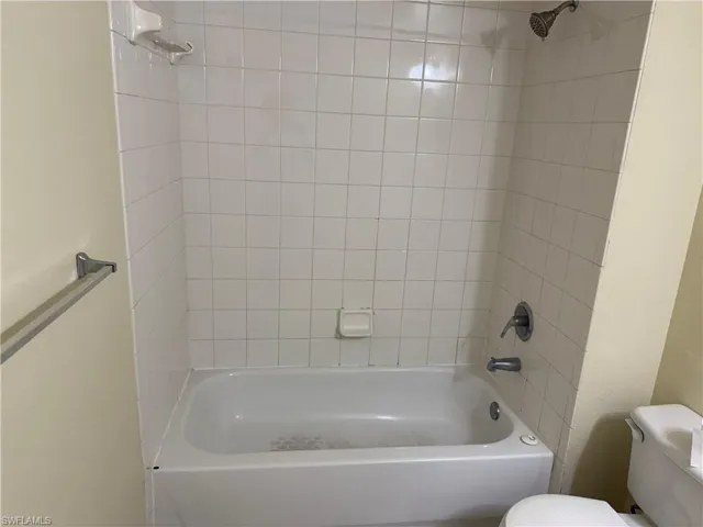 Bathroom featuring shower / washtub combination and toilet