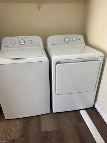 Washroom featuring wood finished floors and separate washer and dryer