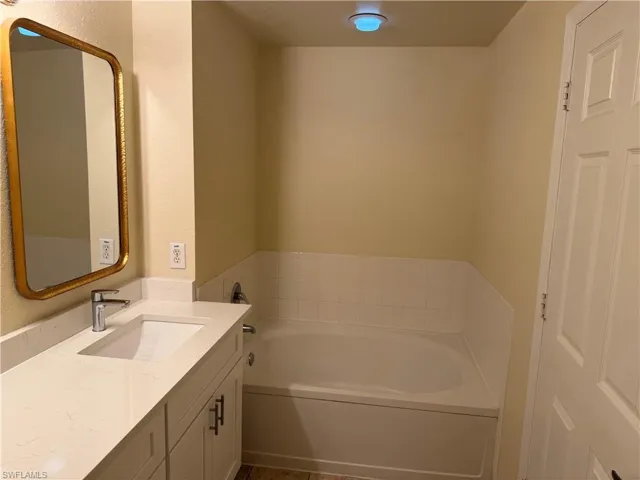Full bathroom with vanity and a garden tub