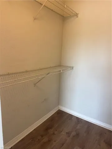 Storage space featuring wood-finish flooring and tiered metal shelving