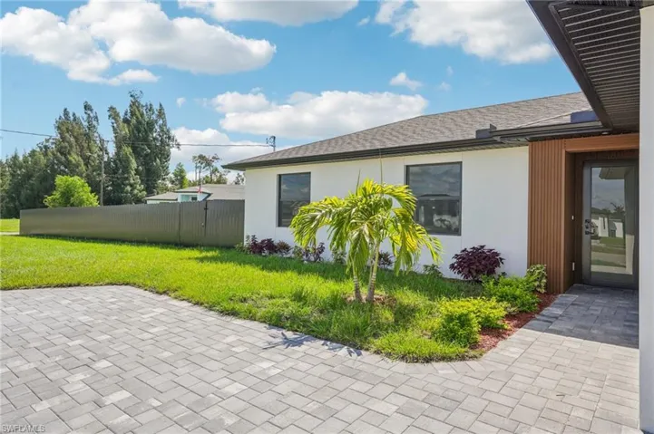 View of side of property featuring stucco siding and a shingled roof