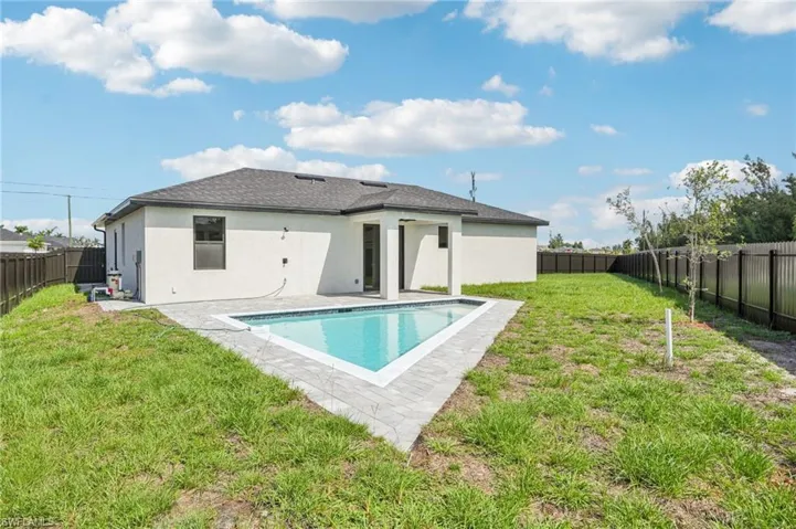 Rear view of house with a fenced backyard, a patio, stucco siding, and a shingled roof