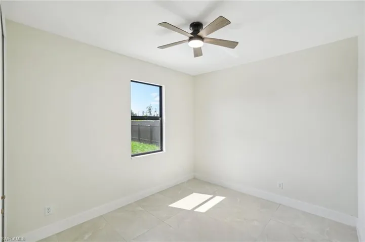 Empty room featuring baseboards and ceiling fan
