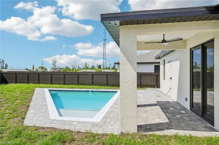 View of pool featuring a patio area, a ceiling fan, and a fenced backyard