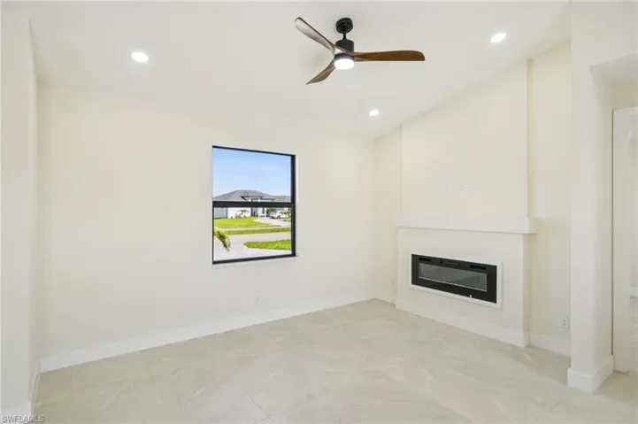Unfurnished living room with a glass covered fireplace, recessed lighting, and a ceiling fan