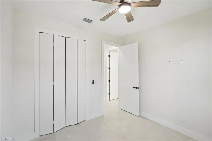 Unfurnished bedroom with ceiling fan and a closet