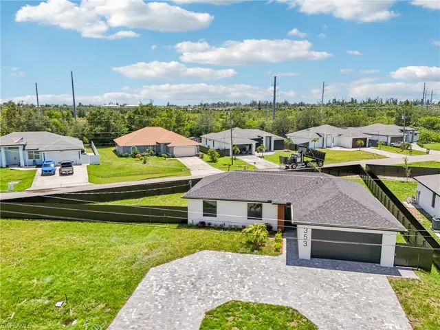 View of front of house with a residential view, curved driveway, a garage, a shingled roof