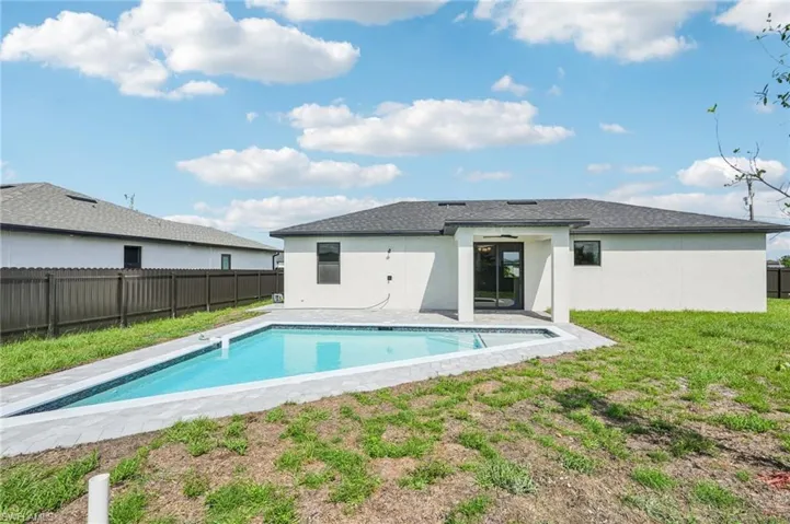 Rear view of property with stucco siding, a patio, a fenced backyard, and roof with shingles