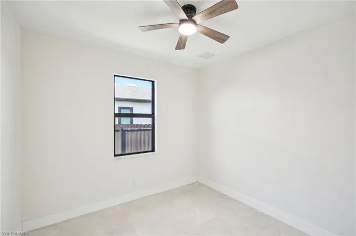 Unfurnished room with light tile patterned floors and a ceiling fan