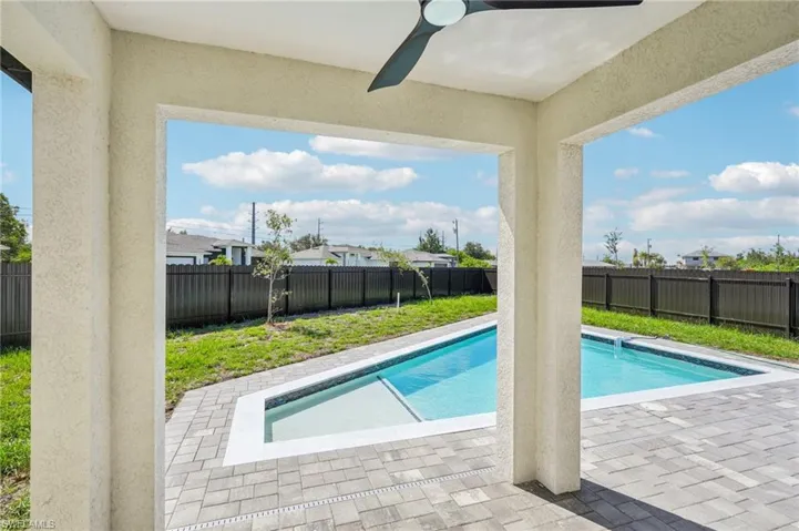View of swimming pool featuring a patio area, a fenced backyard, and ceiling fan