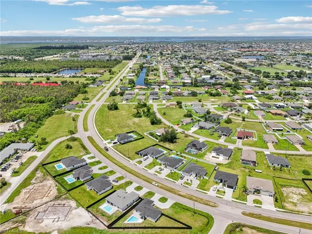 Aerial perspective of suburban area featuring a nearby body of water