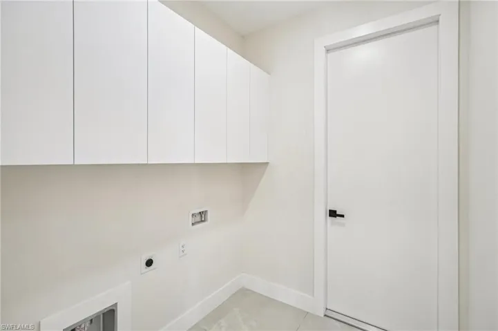 Laundry room with light tile patterned flooring, cabinet space, hookup for an electric dryer, and hookup for a washing machine