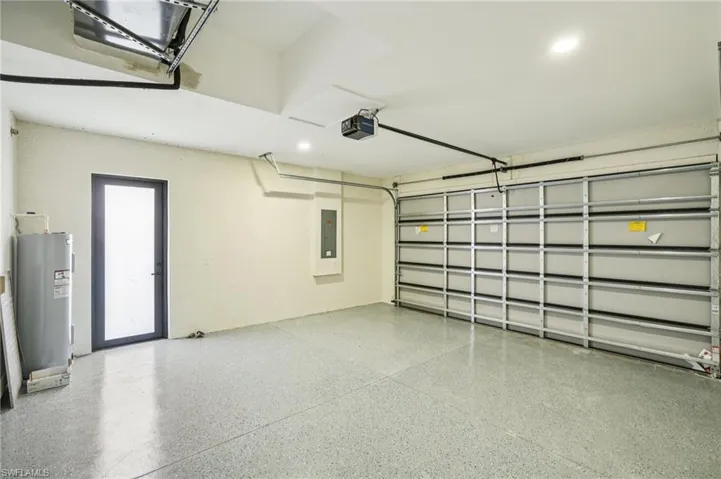 Garage with electric water heater, a garage door opener, and electric panel