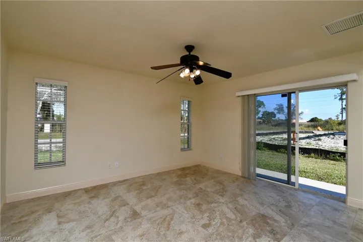 Unfurnished room with ceiling fan and baseboards