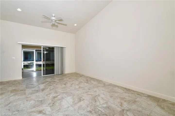 Empty room featuring a ceiling fan, lofted ceiling, and recessed lighting