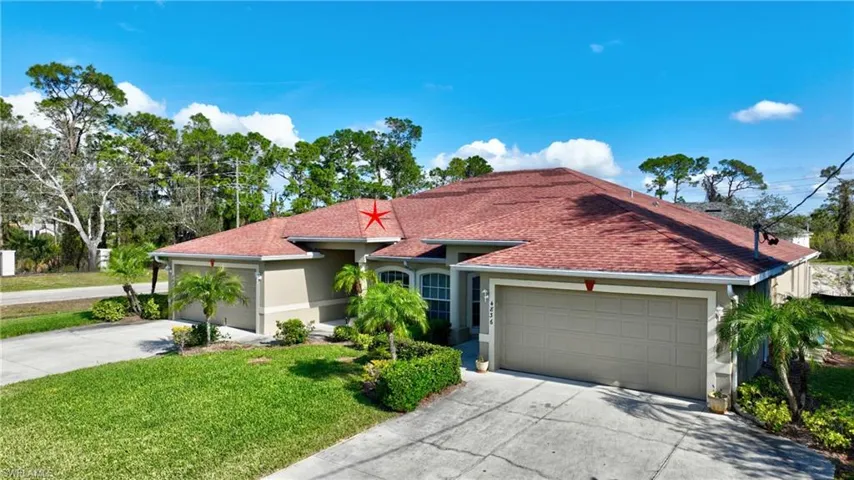 Ranch-style house featuring a garage, stucco siding, concrete driveway, and a front yard
