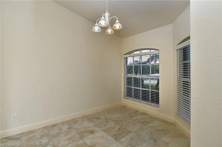Unfurnished room with hanging lights and vaulted ceiling