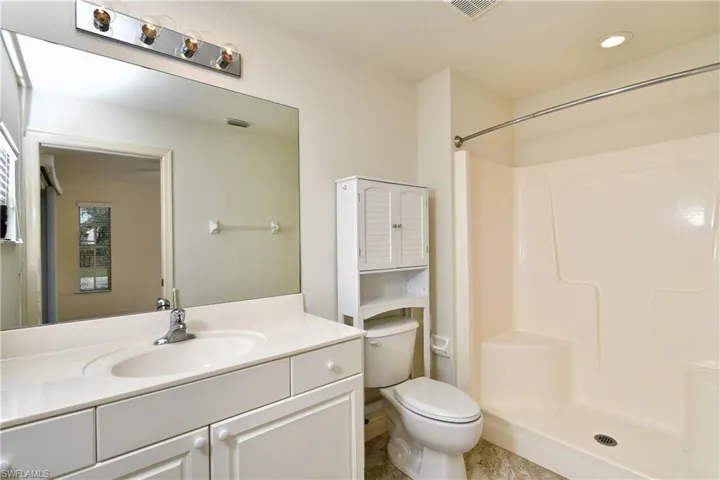 Bathroom with vanity, a shower stall, and recessed lighting