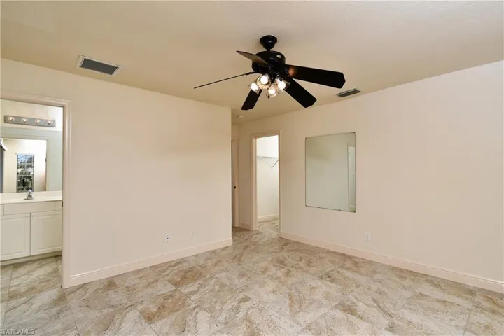 Empty room featuring ceiling fan and baseboards