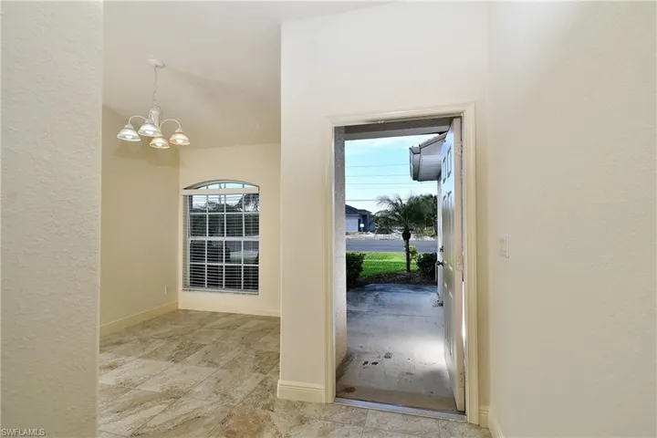 Doorway featuring hanging lights and a textured wall