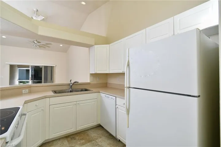Kitchen featuring white appliances, white cabinets, light countertops, a ceiling fan, and recessed lighting