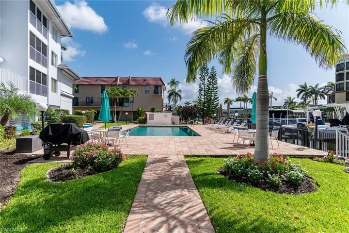 Community pool with grilling area, a patio area, and a yard