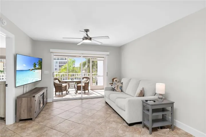 Living room with ceiling fan and light tile patterned floors