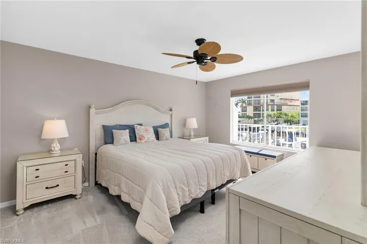 Bedroom with light colored carpet and a ceiling fan