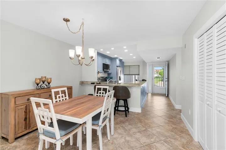 Dining room with a chandelier, light tile patterned floors, and recessed lighting