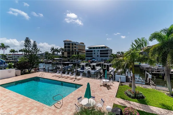 Community pool with a patio area and a water view
