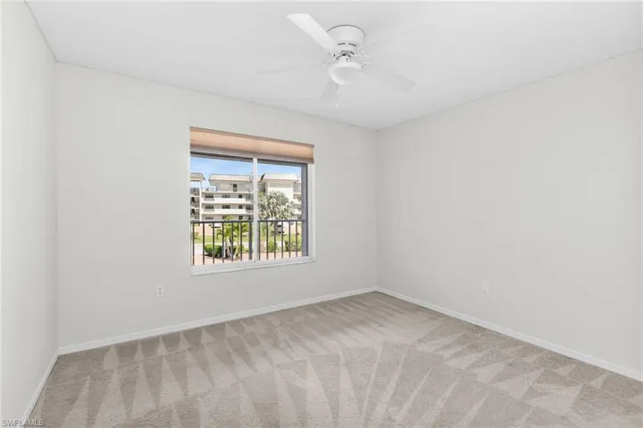 Spare room featuring light carpet and ceiling fan