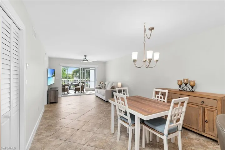 Dining room featuring a chandelier, a ceiling fan, and light tile patterned floors
