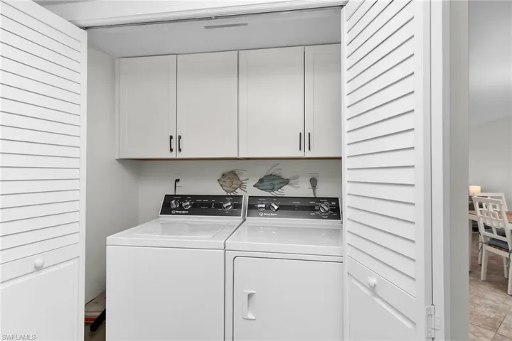 Laundry room featuring washer and clothes dryer and cabinet space