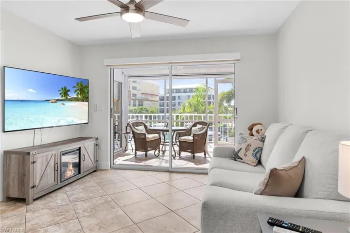 Living area with ceiling fan and light tile patterned floors
