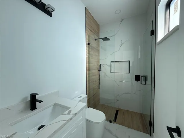 Full bathroom featuring vanity and a marble finish shower