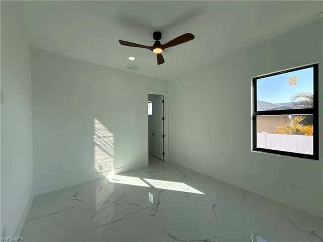 Empty room with a ceiling fan, marble finish flooring, and recessed lighting