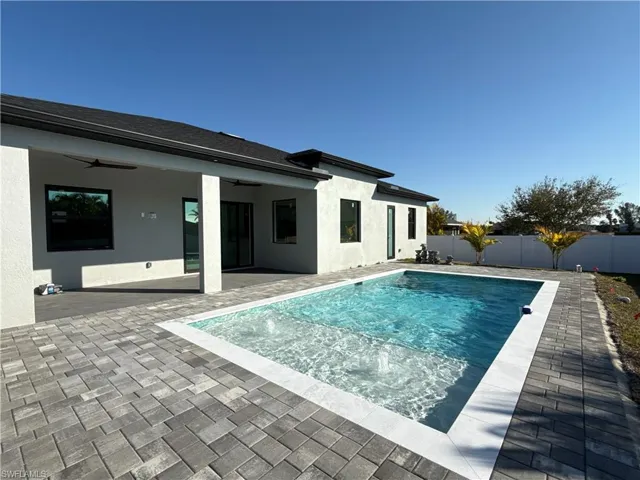 View of swimming pool featuring patio surround and a fenced backyard