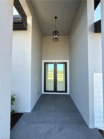 Doorway to property featuring french doors, a patio area, and stucco siding