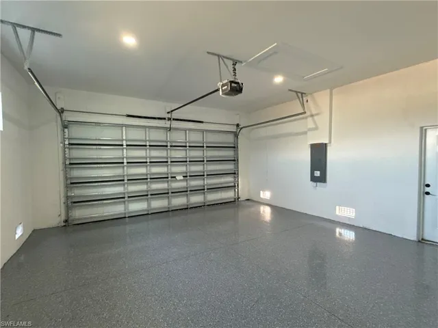 Garage with electric panel and a garage door opener