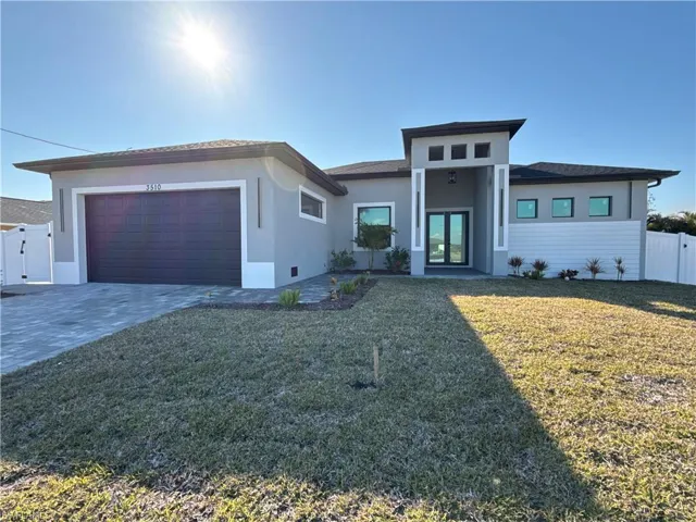 Prairie-style house with a gate, french doors, stucco siding, driveway, and a garage