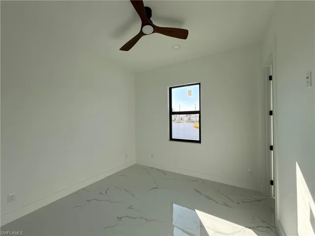 Spare room featuring a ceiling fan and marble finish floors